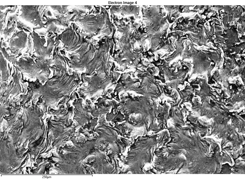 Textured surface of partially melted and recrystallised silicon, resembling turbulent water.
